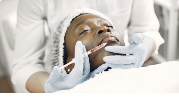 Black woman receiving injectable dermal filler to the lips